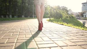 特写时尚的女人穿着红色高跟鞋走在城市街道20秒视频