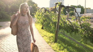 金发女人穿连衣裙漫步在城市街道上39秒视频