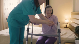 护工帮助老年妇人从床上站起来22秒视频