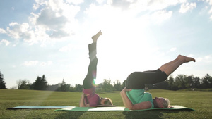两位女士在绿色草坪上做瑜伽运动22秒视频
