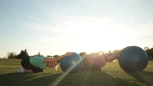 清晨两个女士在草坪上做瑜伽[晨光熹微]视频