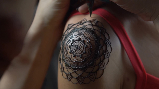 指甲花纹身艺术家在女人的肩膀纹身视频