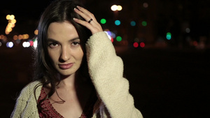 优雅的年轻黑发女人摆着姿势凝视着相机在夜晚街道上17秒视频