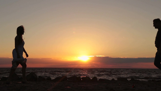 夕阳下一对相爱的夫妇在海滩上牵手视频