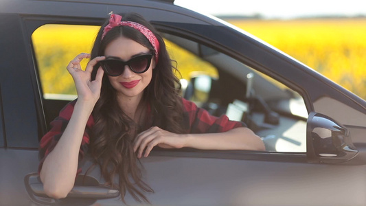 坐在汽车上带着墨镜微笑的女孩视频