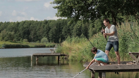 中年男子和小男孩在湖边一起钓鱼视频