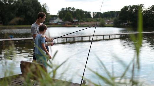 父亲在教小男孩如何钓鱼视频
