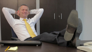 中年经理在工作中脚放在桌子上放松17秒视频