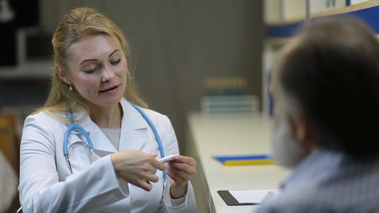 女性医生带听诊器在诊所与病人沟通视频