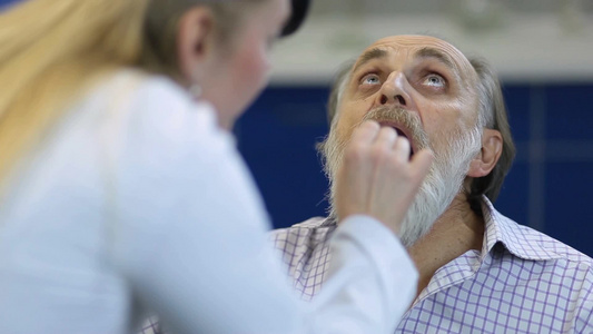 老年男性病人在医疗办公室检查他发炎的喉咙视频