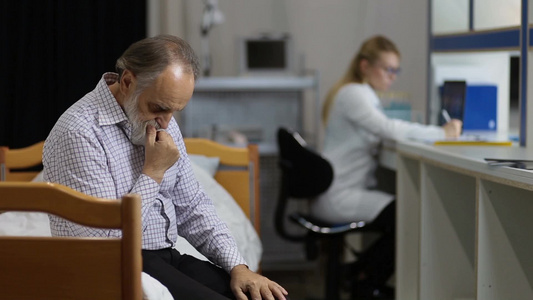 焦虑的老年男性患者坐在检查桌上等待临床结果视频