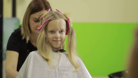 美发师手持剪刀为女孩修剪发型视频