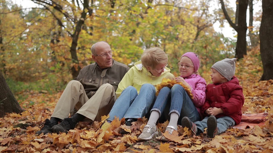 快乐的家庭在秋天的公园里度过空闲时间视频