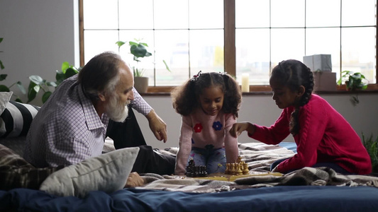 祖父在家里陪孙女下棋视频