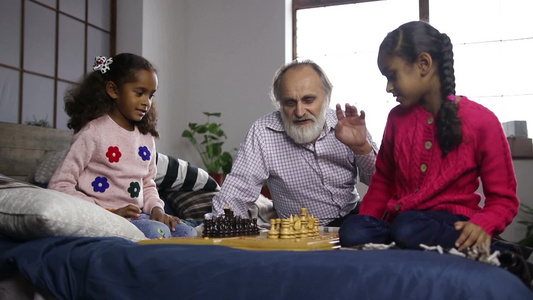 英俊的爷爷教他可爱的孙女下棋视频