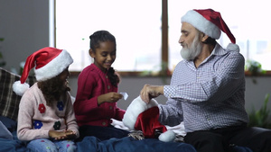 两个女孩伸手到圣诞老人的帽子里抽签礼物23秒视频