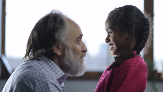 白胡子老人给小女孩讲着有趣的故事视频