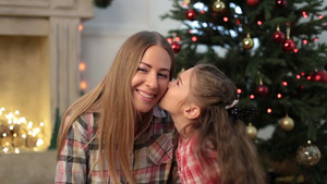 可爱的小女孩在圣诞节亲吻她美丽的母亲9秒视频