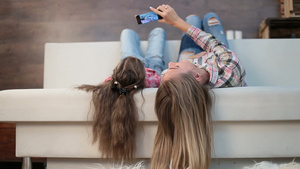年轻女性和小女孩躺在沙发上自拍9秒视频