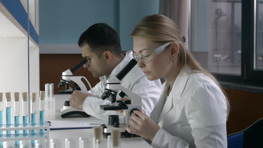 集中女性科学家研究员和她的年轻男性同事在实验室进行实验视频