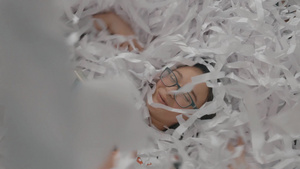 女孩躺在白色纸屑里拍摄有趣的照片13秒视频
