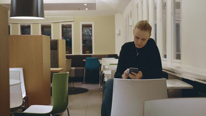 年轻的女人在咖啡馆看手机上网12秒视频