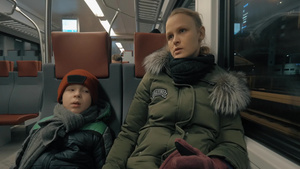 冬天晚上乘火车旅行的母子两人坐在车厢里和儿子说话16秒视频