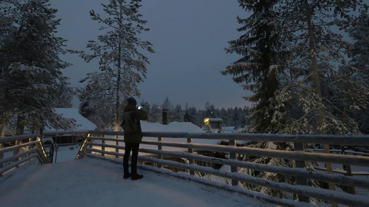 男子在夜间拍摄雪景视频