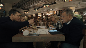 一家人一起在餐馆吃晚饭年纪大些的中年人在用平板电脑工作28秒视频