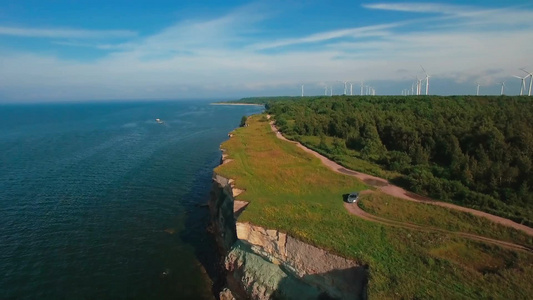 沿着海岸线飞行陆地上有风力发电机视频