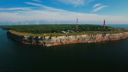 从海上和陆地上看海岸线古老的灯塔和风力涡轮机视频