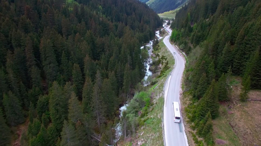 山区公路上驾驶白色公共汽车的鸟瞰图视频