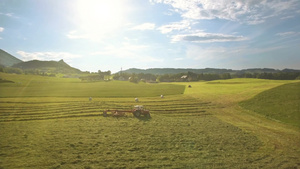 在奥地利的山区拖拉机在田野上收集干草14秒视频