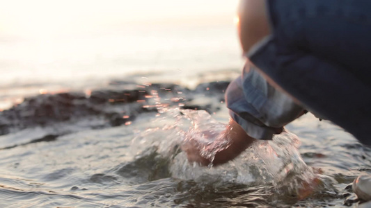 一个小女孩在海边泼海水慢动作视频