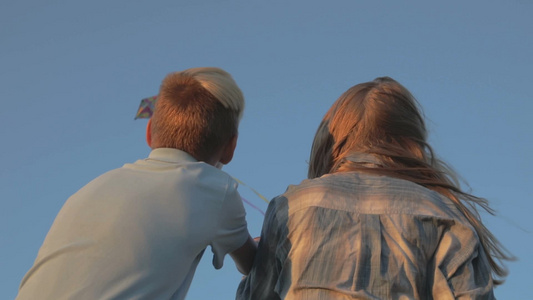 男孩和女孩在强风中放风筝视频