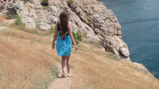 女子走在岩石边的小路上视频