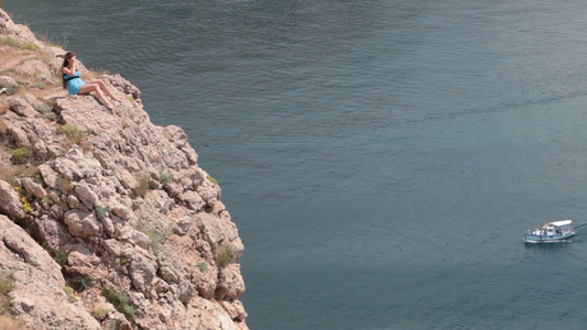 年轻的女人躺在克里米亚巴拉克拉瓦湾黑海附近的悬崖上视频