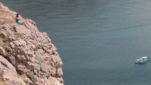 年轻的女人躺在克里米亚巴拉克拉瓦湾黑海附近的悬崖上23秒视频