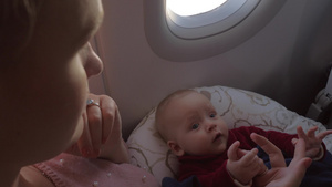 年轻女人在飞机上照顾自己的宝贝女儿20秒视频