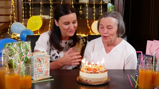 中年女性为老人过生日并吹生日蜡烛视频