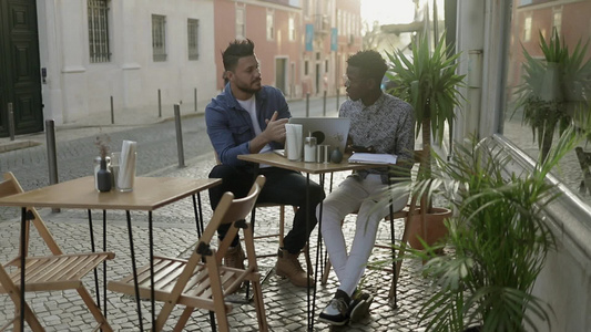 多种族的男人在户外咖啡馆里讨论在咖啡馆的工作[魔族]视频