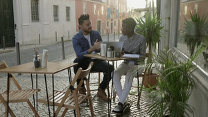 多种族的男人在户外咖啡馆里讨论在咖啡馆的工作11秒视频