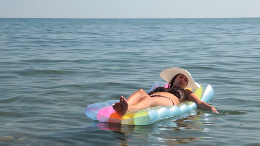 年轻女人躺在海上的充气船上视频