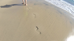 男人走在沙滩上留下沙子的脚印32秒视频