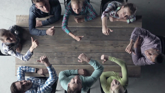 一群年轻人围坐在桌子前抬头向上剧情大拇指视频