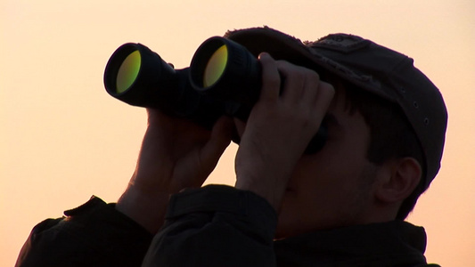 年轻人在日落时透过望远镜望向远方视频