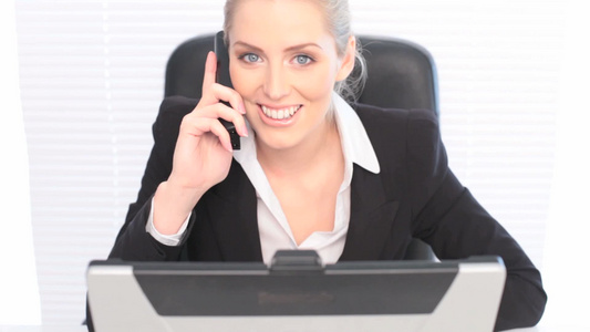 商务女性用手机打电话微笑着向着镜头[女同胞]视频