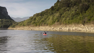 年轻男人在河流中划着红色独木舟24秒视频