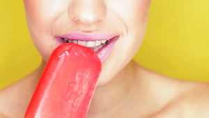 一个女人在吃红色冰淇淋微笑时露出的洁白牙齿唇部特写16秒视频