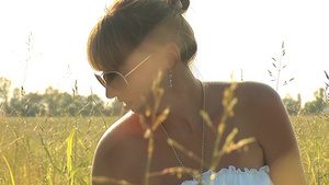 穿白色衣服戴着太阳镜的在绿色草地上女人20秒视频